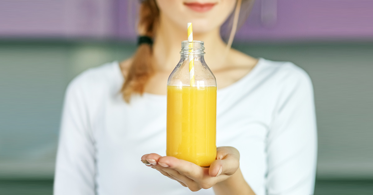 woman holding a bottle of fruit juice